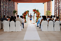 Jessie and Taylor exchange vows at their destination wedding altar, guests seated on both sides.