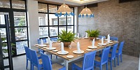 Bahia Principe Grand Samana dining table for twelve with blue chairs and plant centerpieces, ideal for a destination wedding.