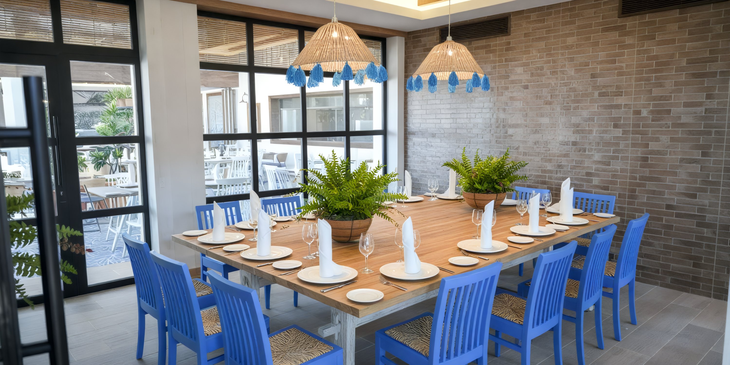 Bahia Principe Grand Samana dining table for twelve with blue chairs and plant centerpieces, ideal for a destination wedding.