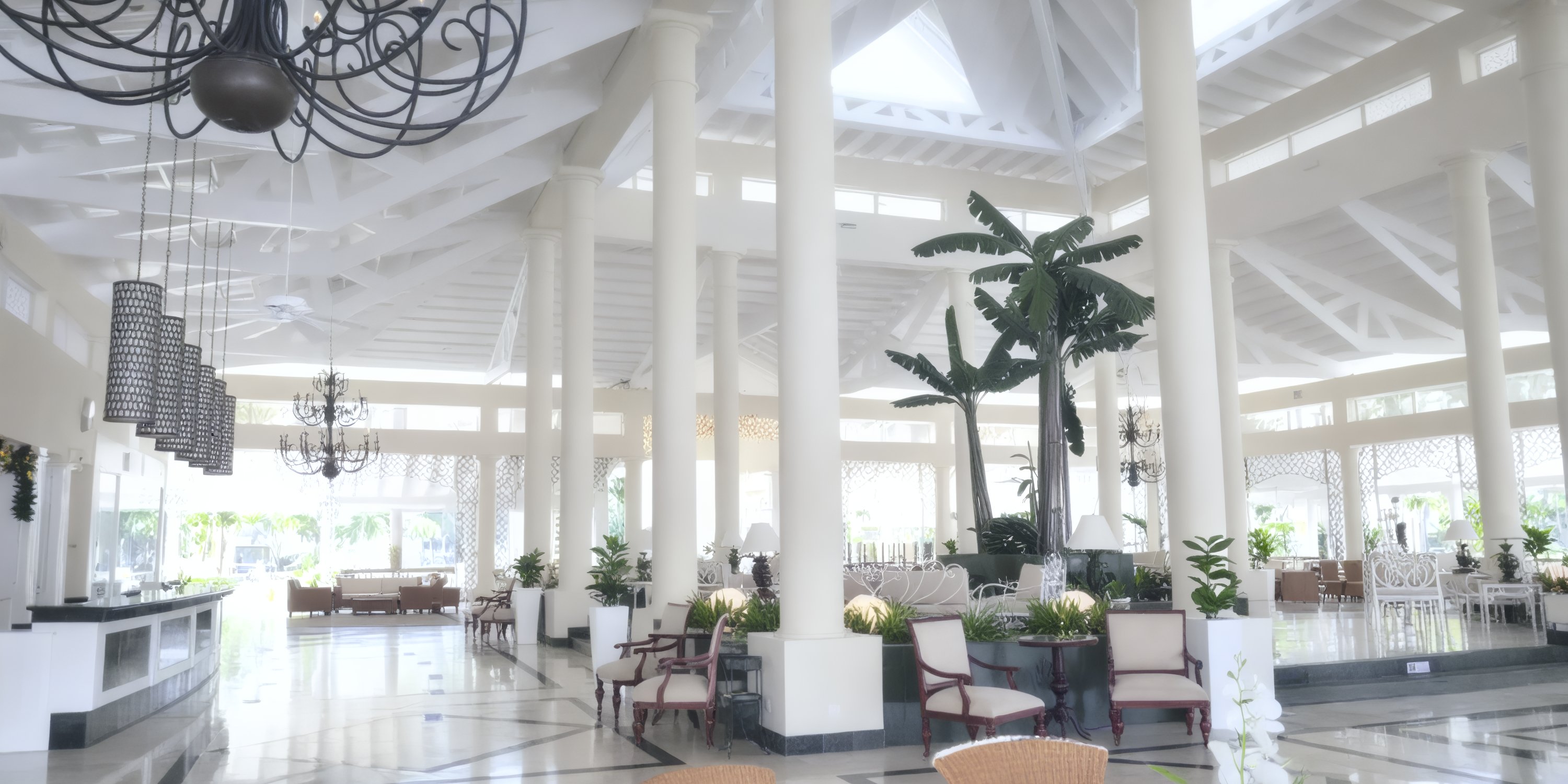 Bahia Principe Grand Samana lobby—ideal for a destination wedding—with white columns and chandeliers.