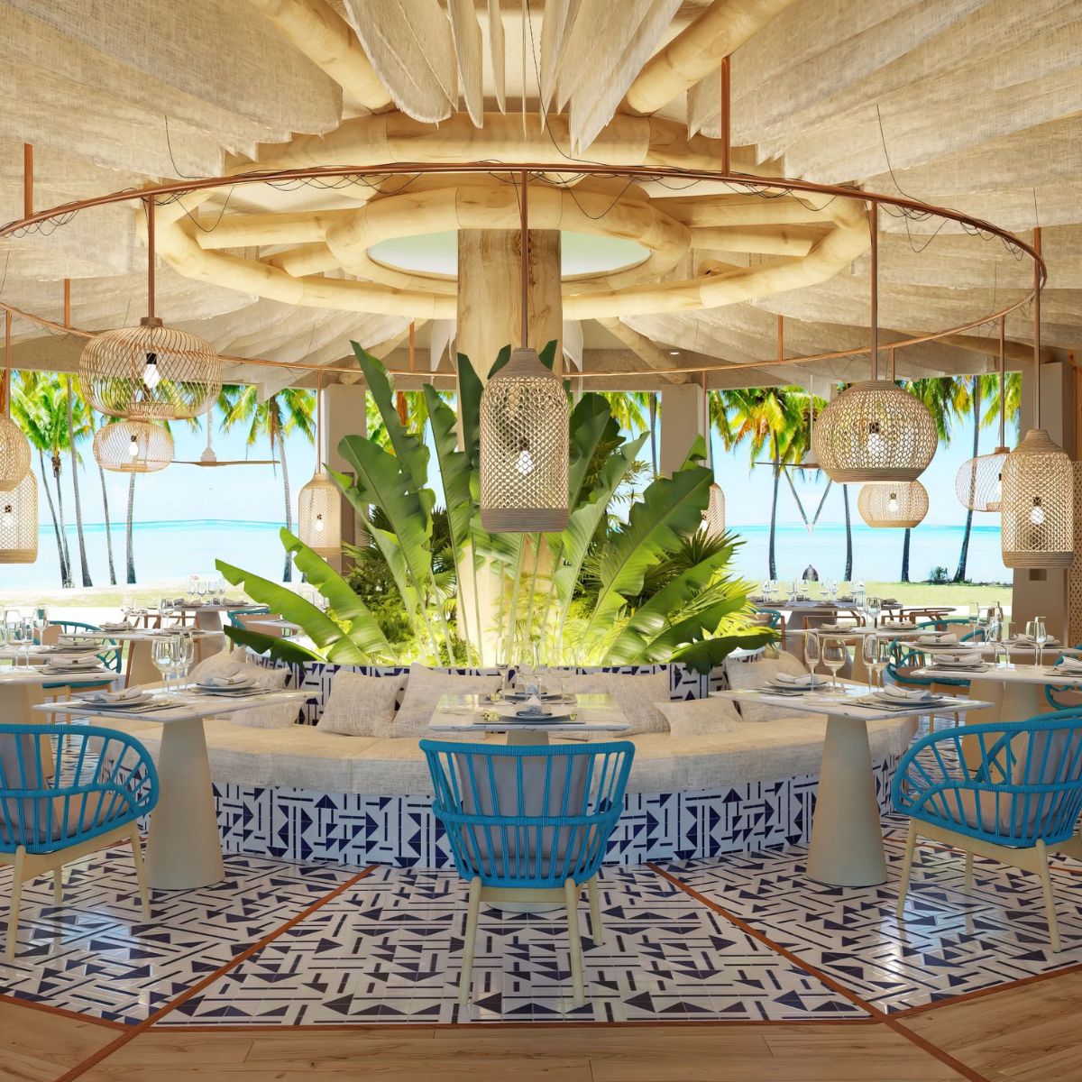 Tropical beachfront restaurant with blue chairs, patterned floor, and central plant—ideal for a destination wedding.