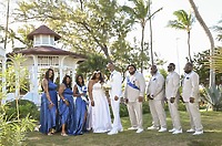 The Richard and Keily destination wedding party poses outdoors, dressed in blue and beige attire.