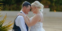 Bride and groom embrace and smile outdoors during their destination wedding, radiating happiness.