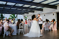 Alicia and Brian share their first dance as newlyweds at their wedding, surrounded by seated guests.