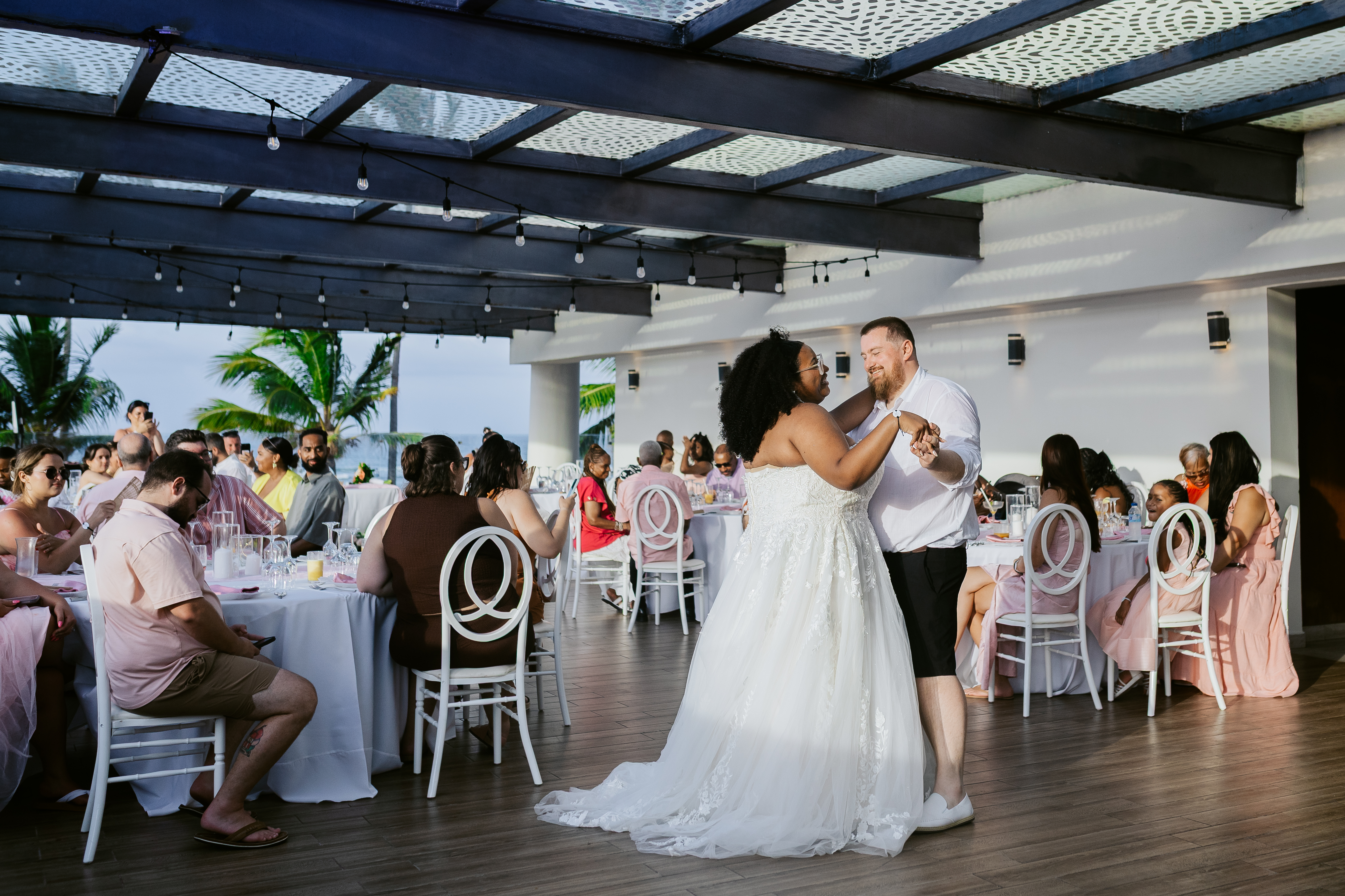 Alicia and Brian share their first dance as newlyweds at their wedding, surrounded by seated guests.