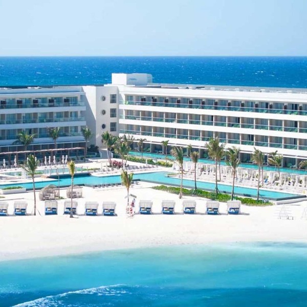 Modern beachfront resort ideal for a destination wedding, featuring pools, palm trees, and ocean views.