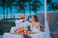 Billi and Trevor toast with champagne at a beautifully decorated destination wedding table outdoors.