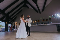 Billi and Trevor share their first dance at their destination wedding in a spacious, high-ceilinged venue.