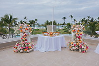 The Billi and Trevor wedding table features florals on a terrace with palm and ocean views, perfect for a destination wedding.