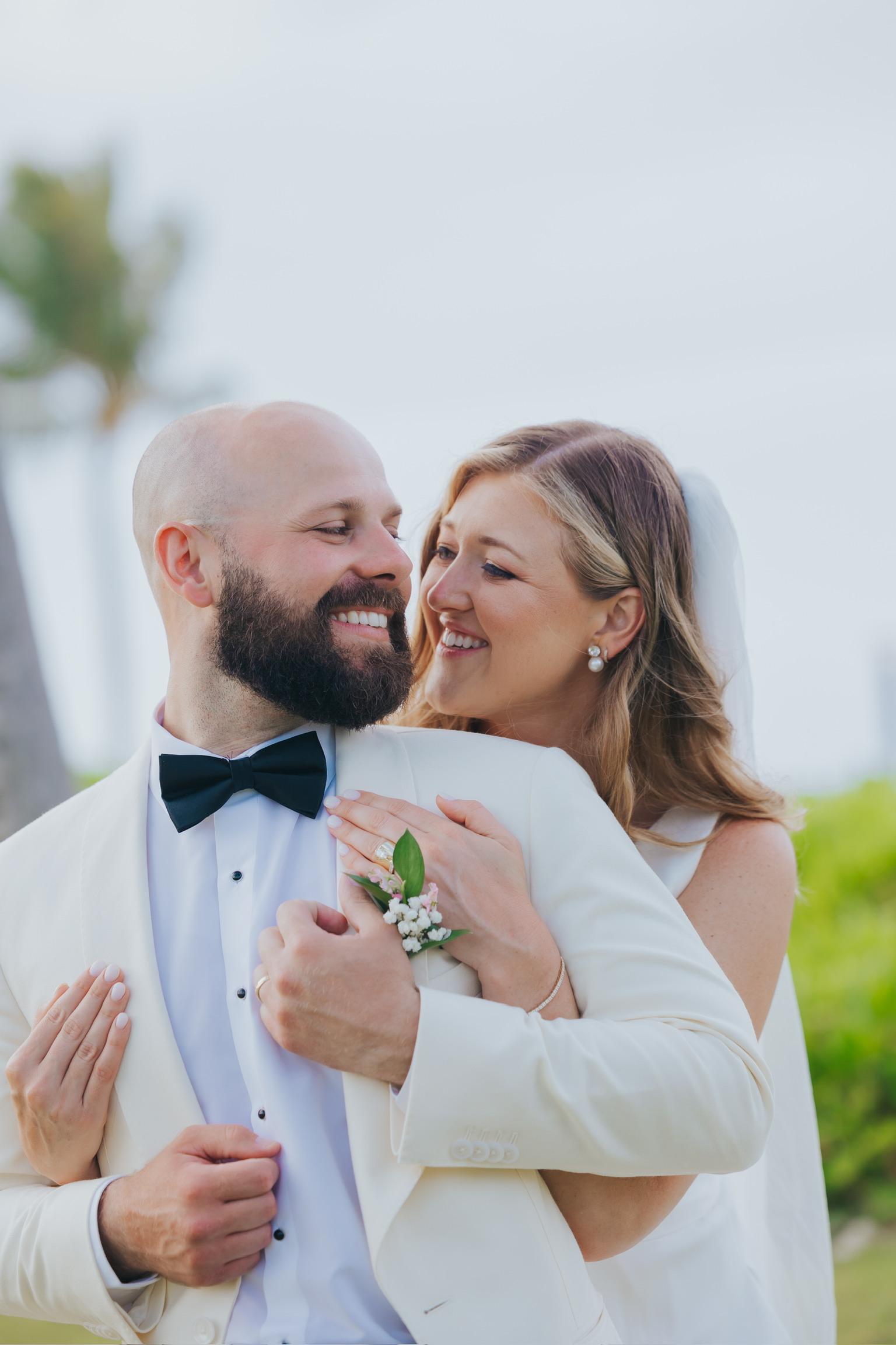 Billi and Trevor share a joyful embrace outdoors on their destination wedding day.