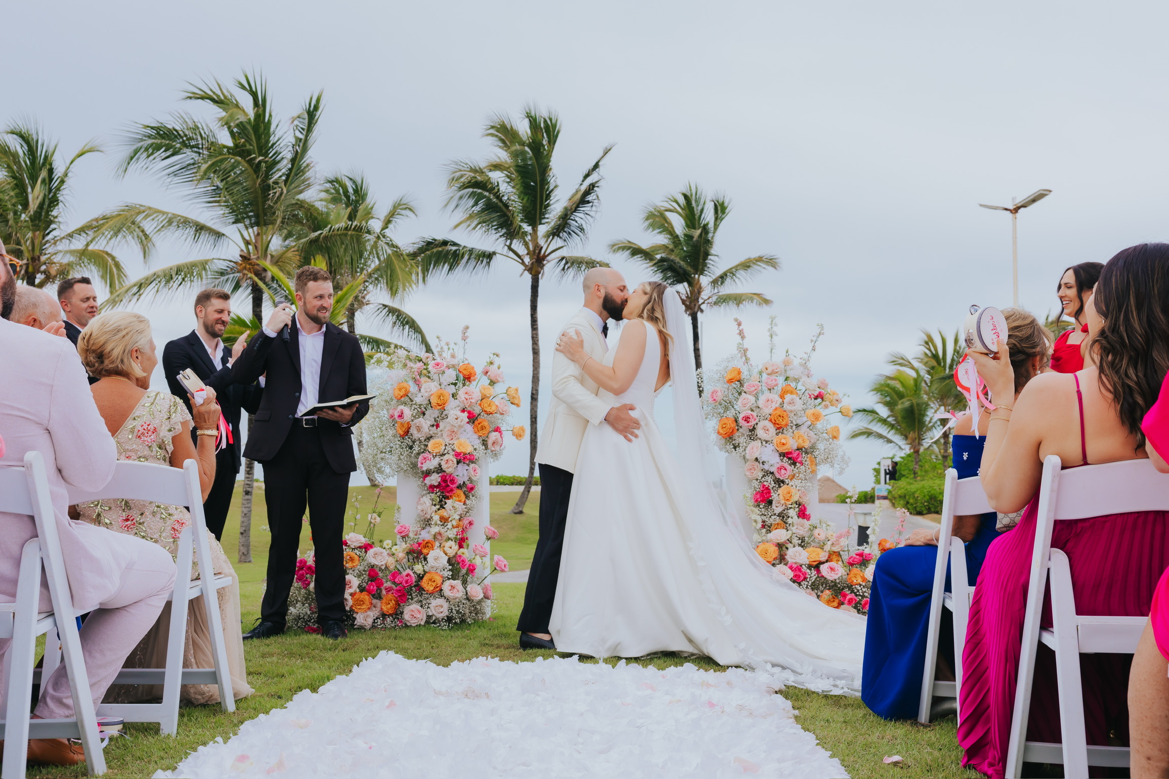 Billi and Trevor (Copy) share a kiss at their destination wedding, surrounded by guests on both sides.