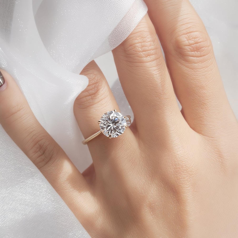 Hand with a gold ring featuring a large round diamond, holding sheer white fabric at a destination wedding.