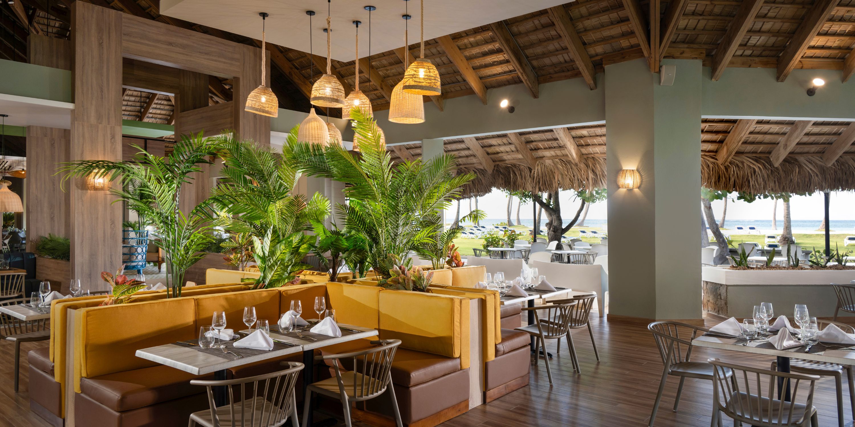 Wyndham Alltra Punta Cana: a dreamy destination wedding spot with yellow booths, lush plants, and views.