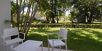 Wyndham Alltra Punta Cana patio set for a destination wedding, with two white chairs and grassy yard view.