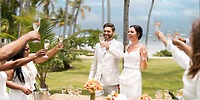 The newlyweds celebrate with a toast among guests at their destination wedding on Punta Cana beach.