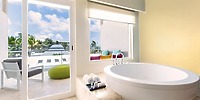Elegant modern bathroom at Iberostar, perfect for a destination wedding stay, with tub and balcony view.