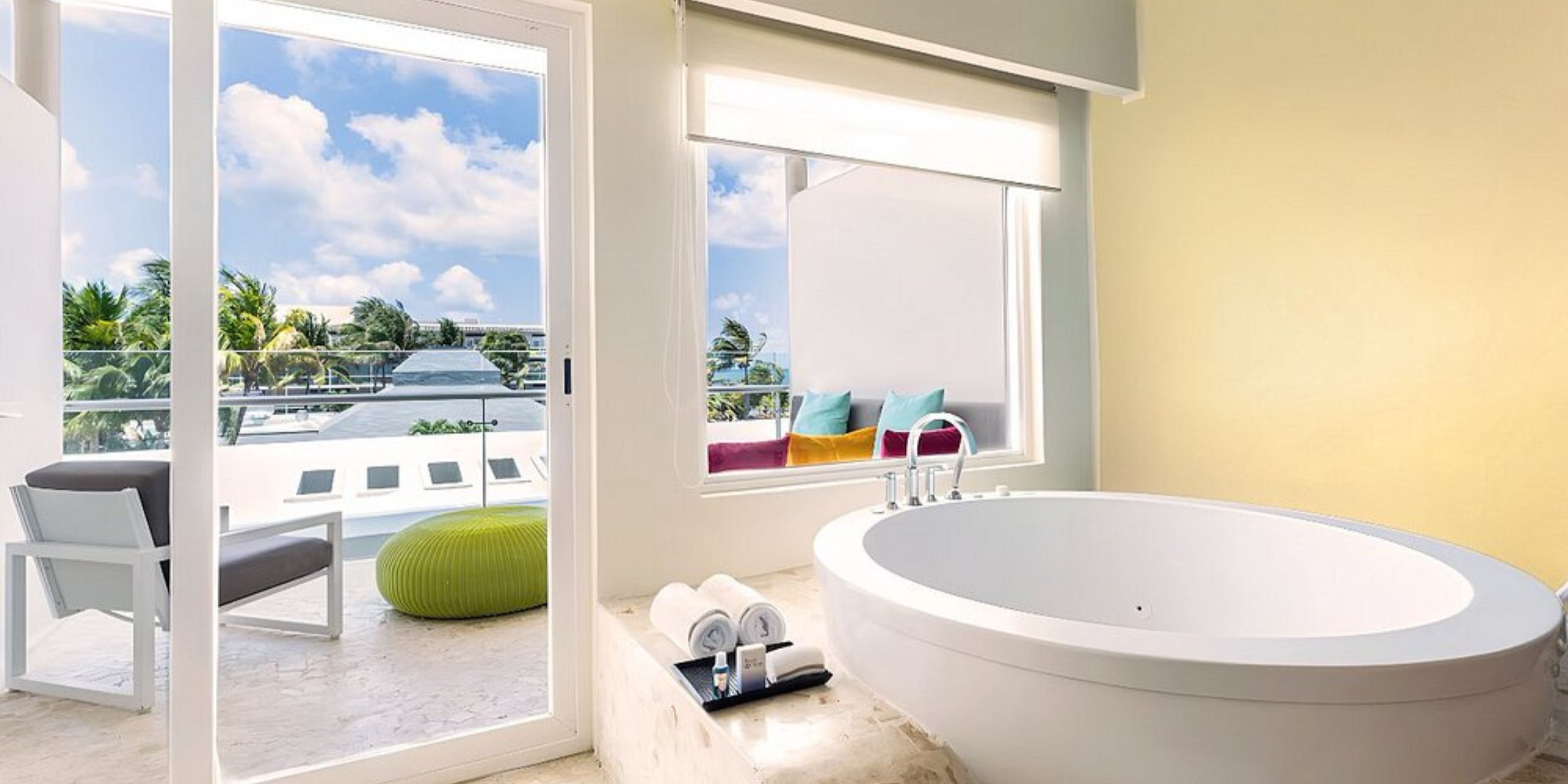 Elegant modern bathroom at Iberostar, perfect for a destination wedding stay, with tub and balcony view.