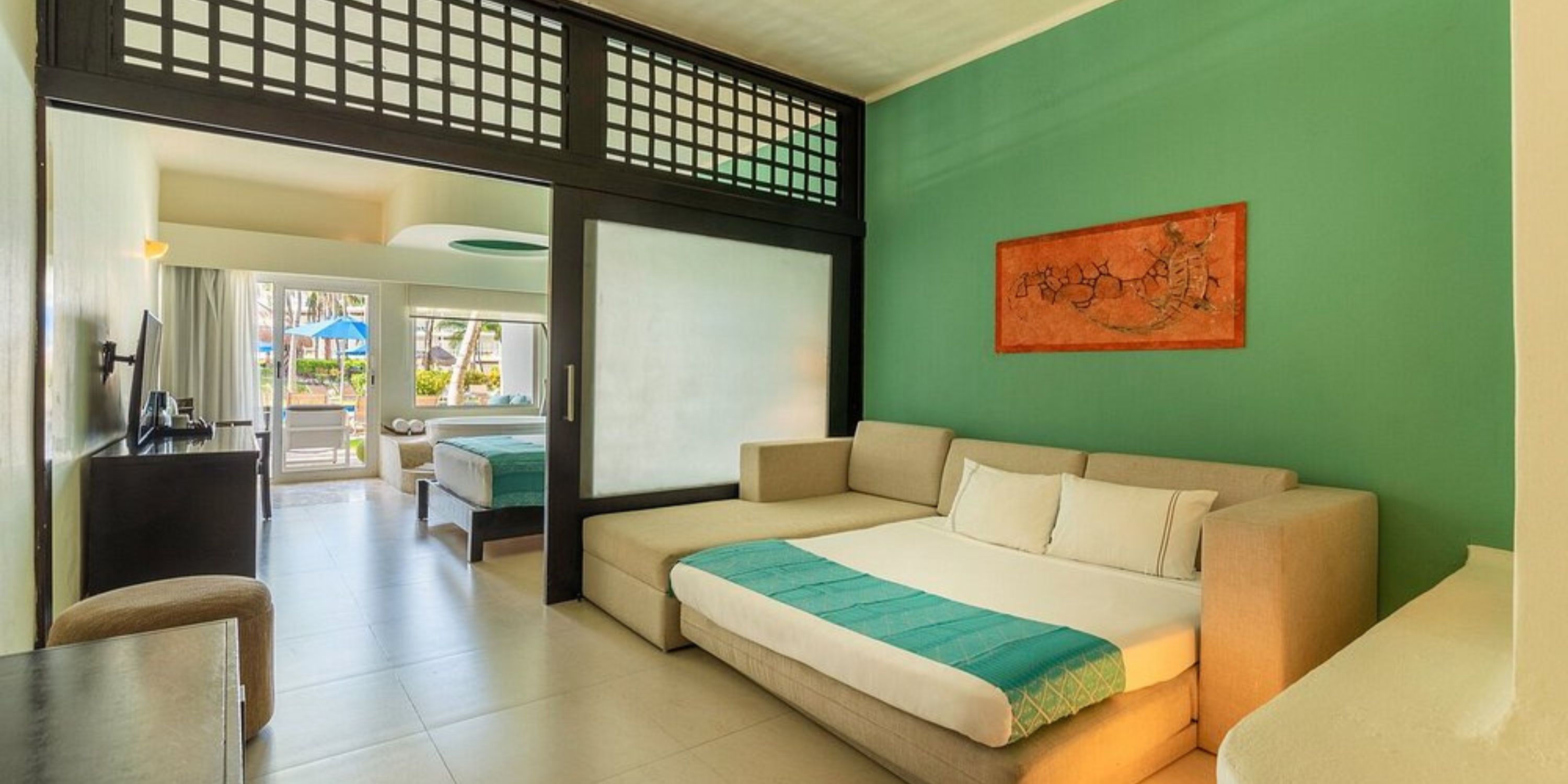Chic room at Iberostar Selection Riviera Cancun, ideal for destination weddings, with sofa bed and patio view.
