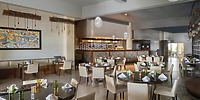 Chic interior at Iberostar Selection Riviera Cancun, perfect for a destination wedding, with round tables and an open kitchen.