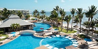 Resort pools and palms at Iberostar Selection Riviera Cancun create a stunning destination wedding backdrop by the sandy beach and ocean.