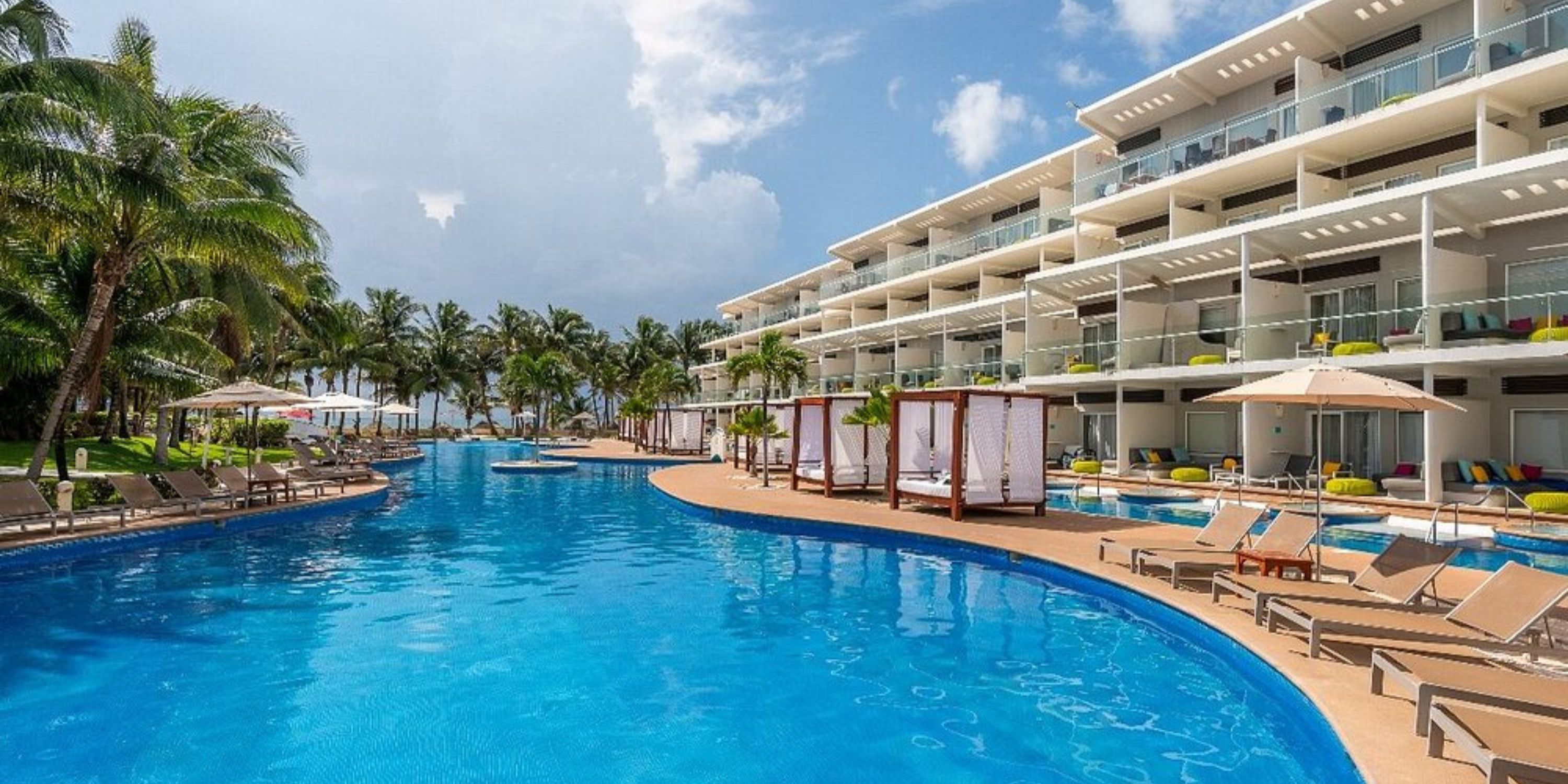 Resort pool at Iberostar Selection Riviera Cancun, perfect for a destination wedding, with loungers and palms.