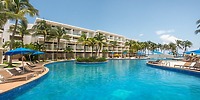 Iberostar Selection Riviera Cancun resort pool, ideal for a destination wedding, with lounge chairs, palm trees, and umbrellas.