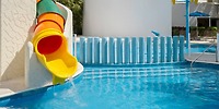 Colorful tube slide leads into a clear blue pool, perfect for a fun destination wedding at Iberostar.