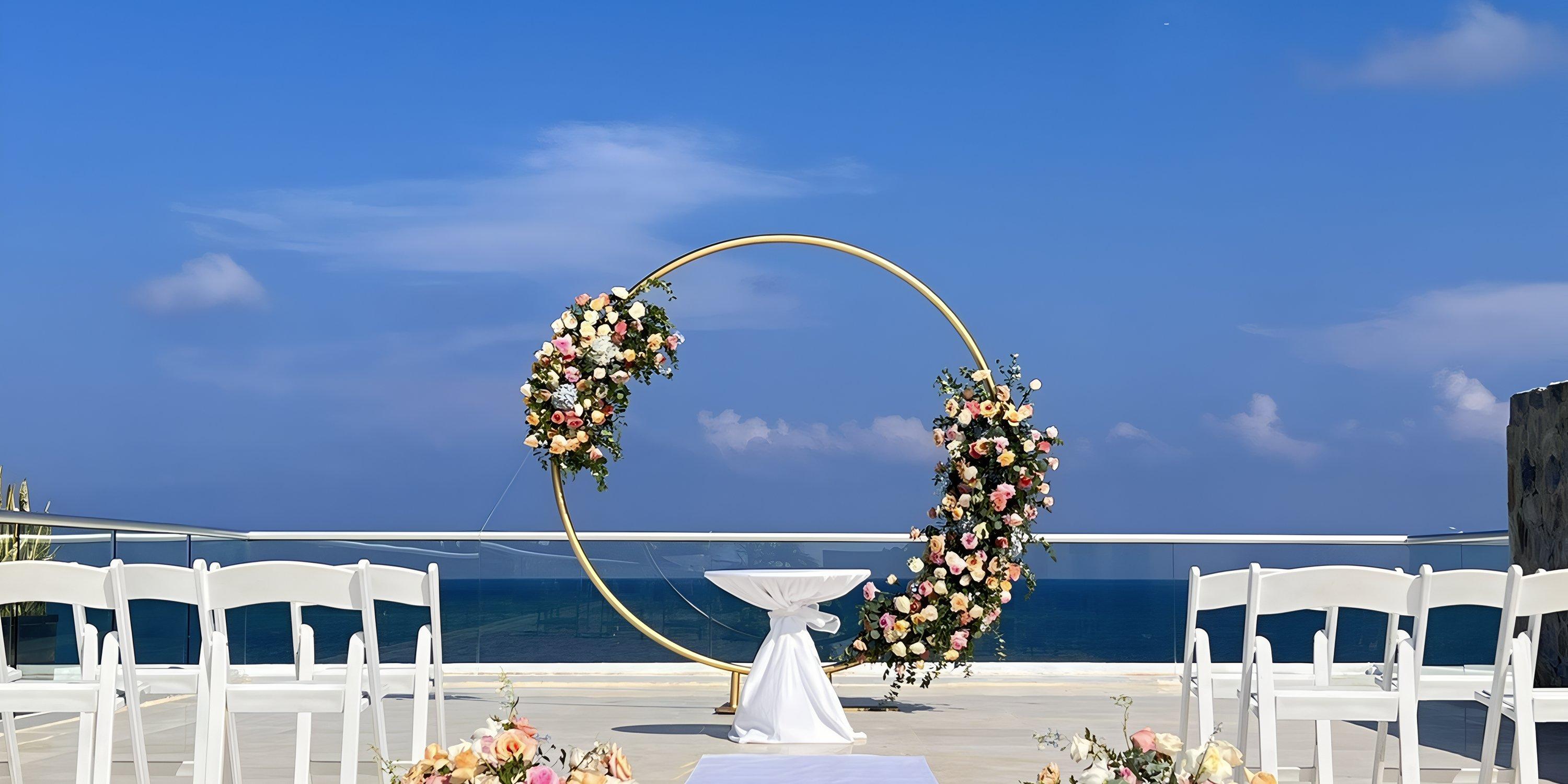 Destination wedding at Iberostar Selection Riviera Cancun, featuring white chairs and a floral round arch.