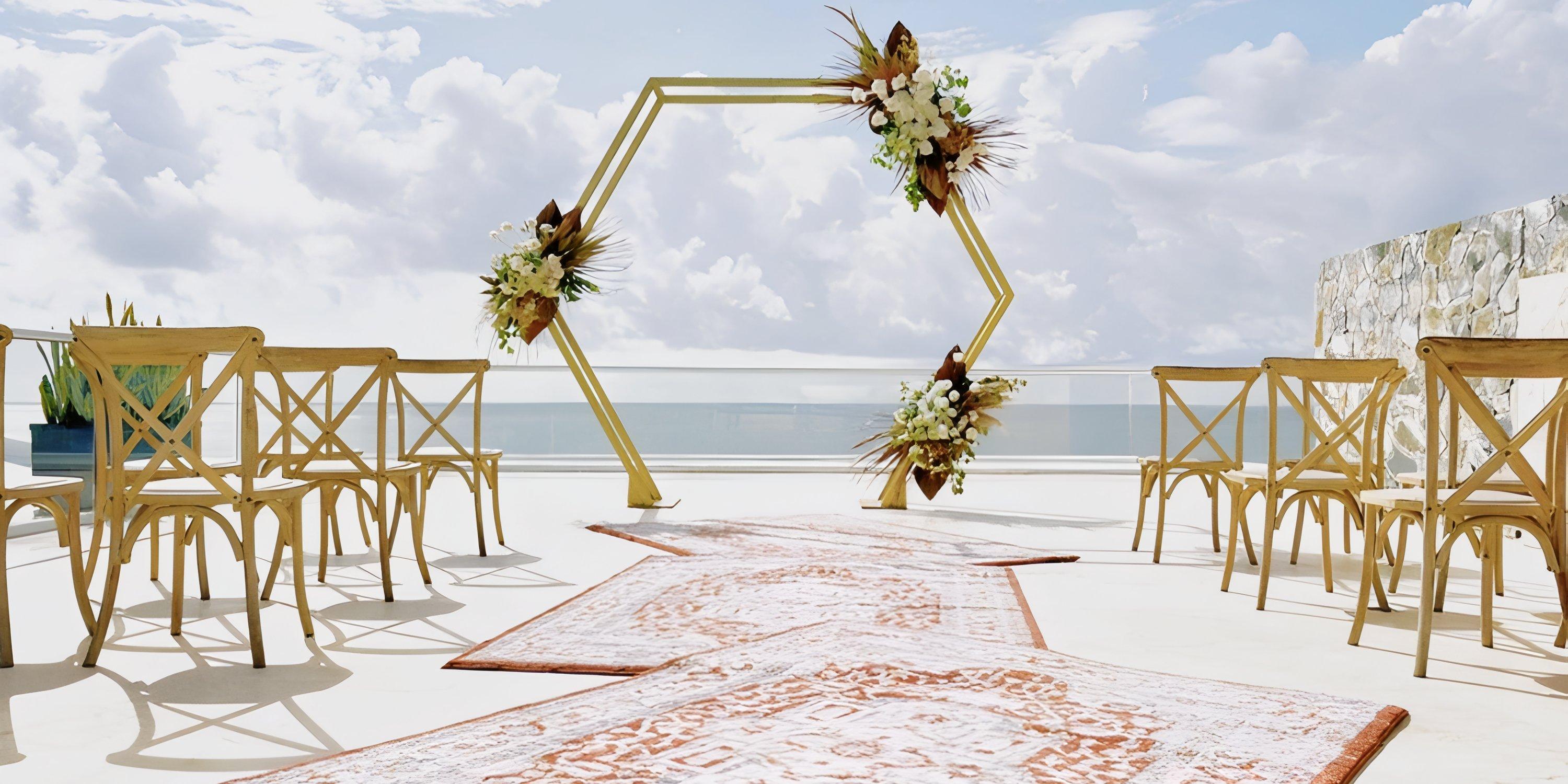 Iberostar Selection Riviera Cancun: destination wedding setup with wooden chairs and a floral ceremony arch.