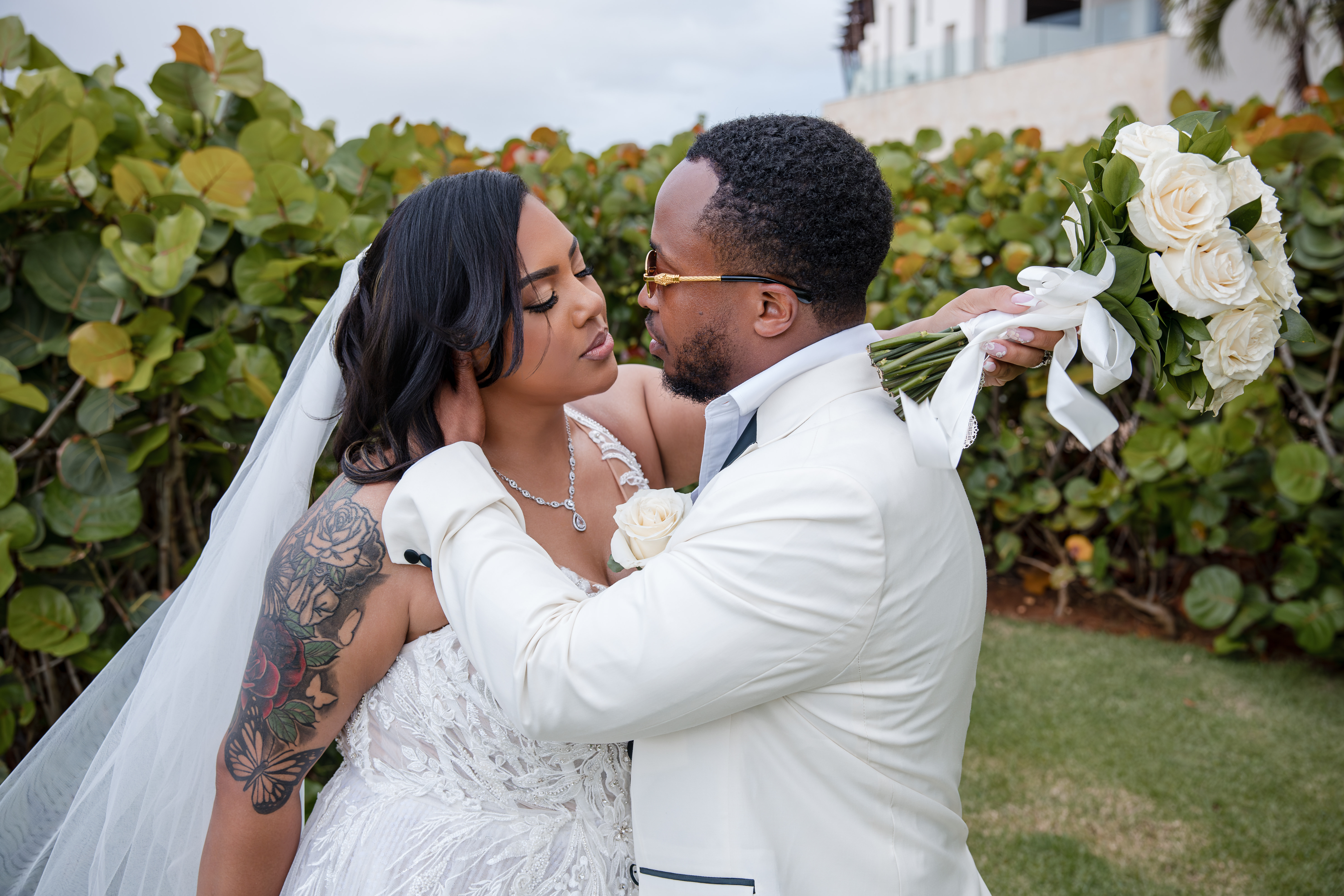 Leah and Ben share an intimate moment at their destination wedding, surrounded by lush greenery outdoors.