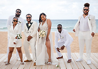 Wedding party dressed in white on a beach boardwalk with the bride and groom at a destination wedding.