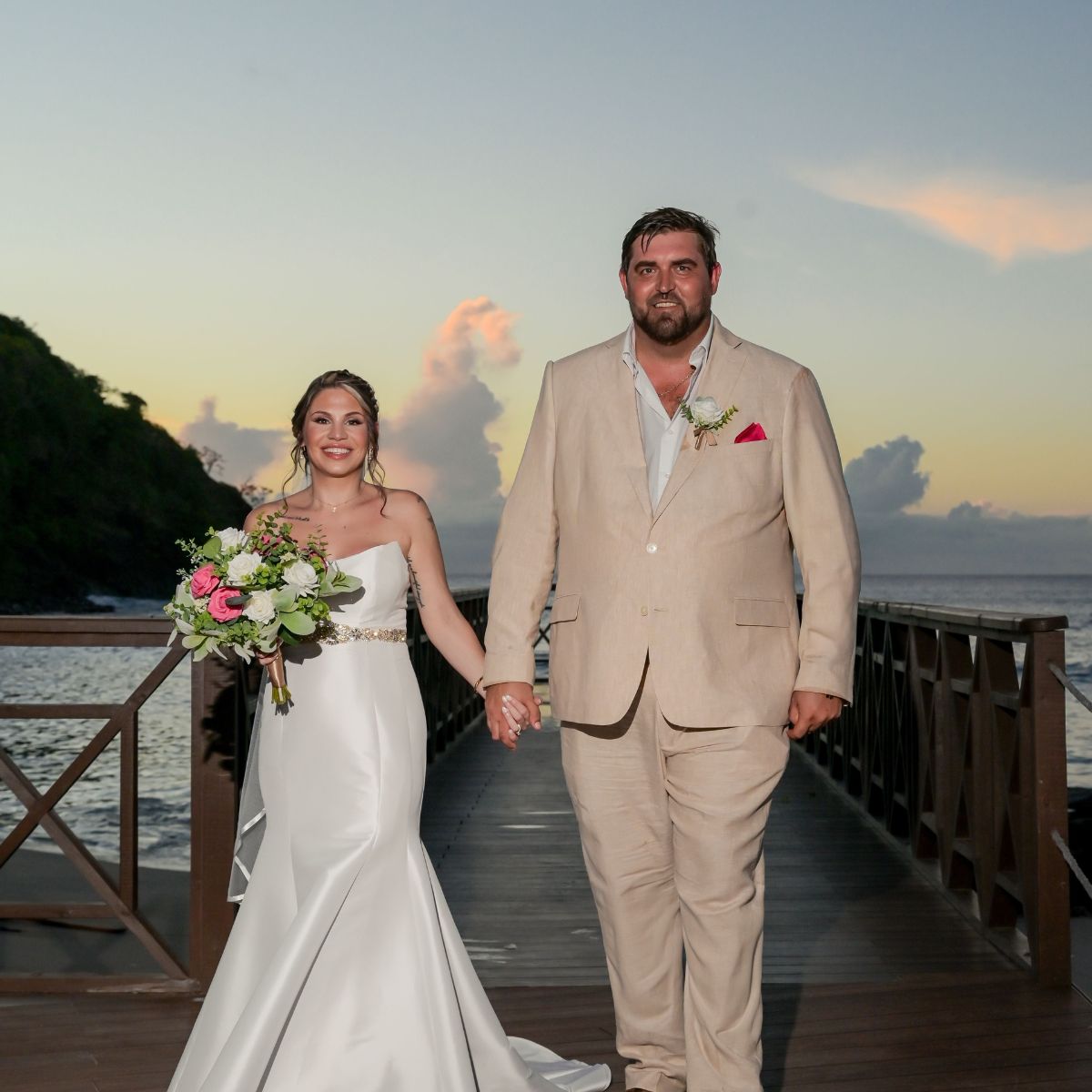 James and Brianna holding hands on a wooden pier at sunset during their destination wedding.