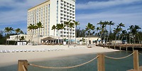 Warwick Paradise Island Bahamas: Ideal beachfront hotel for a destination wedding, with palms and lounge chairs.