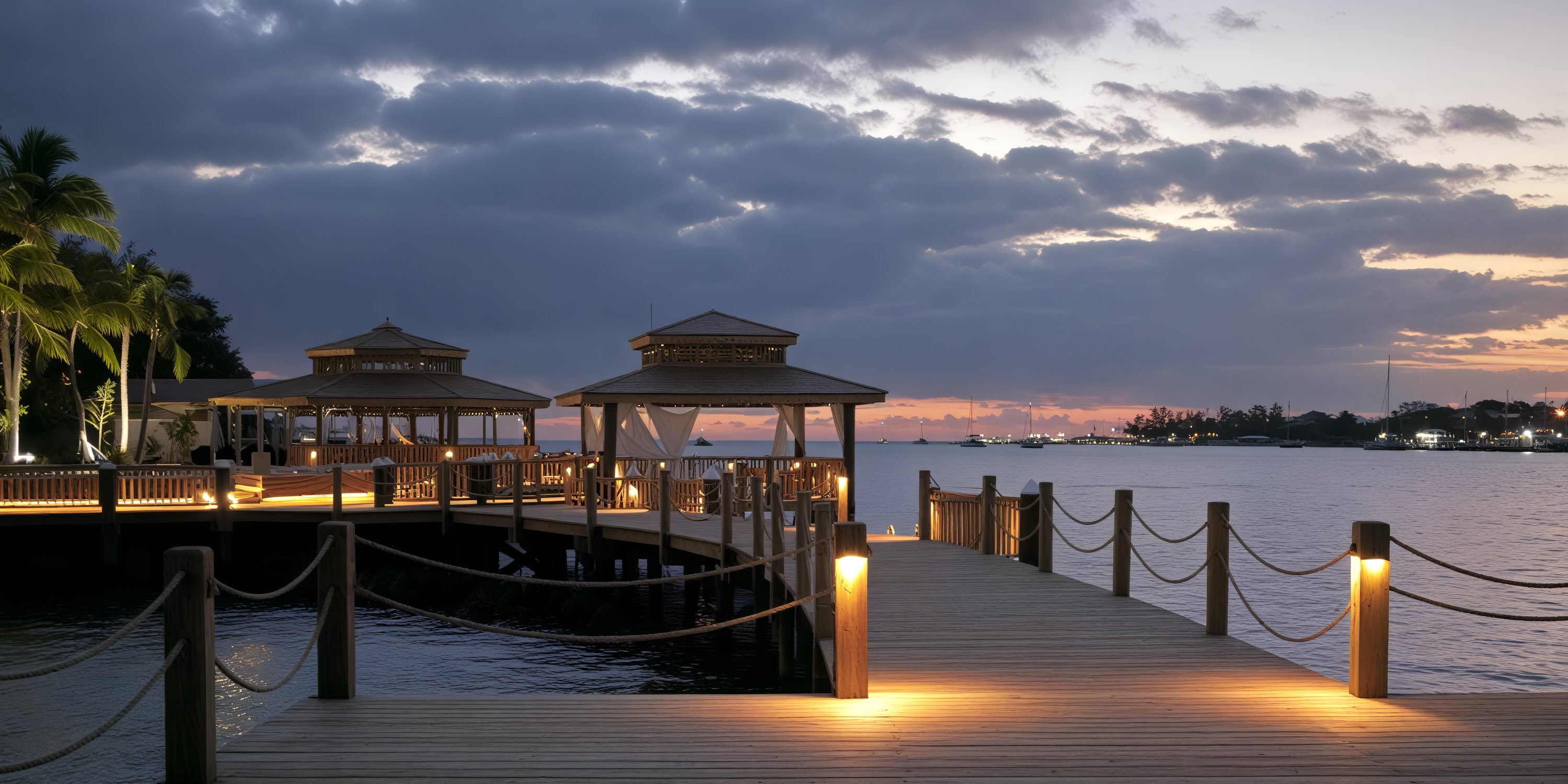 Pier with gazebos at Warwick Paradise Island Bahamas, ideal for destination wedding sunsets and lit walkway.