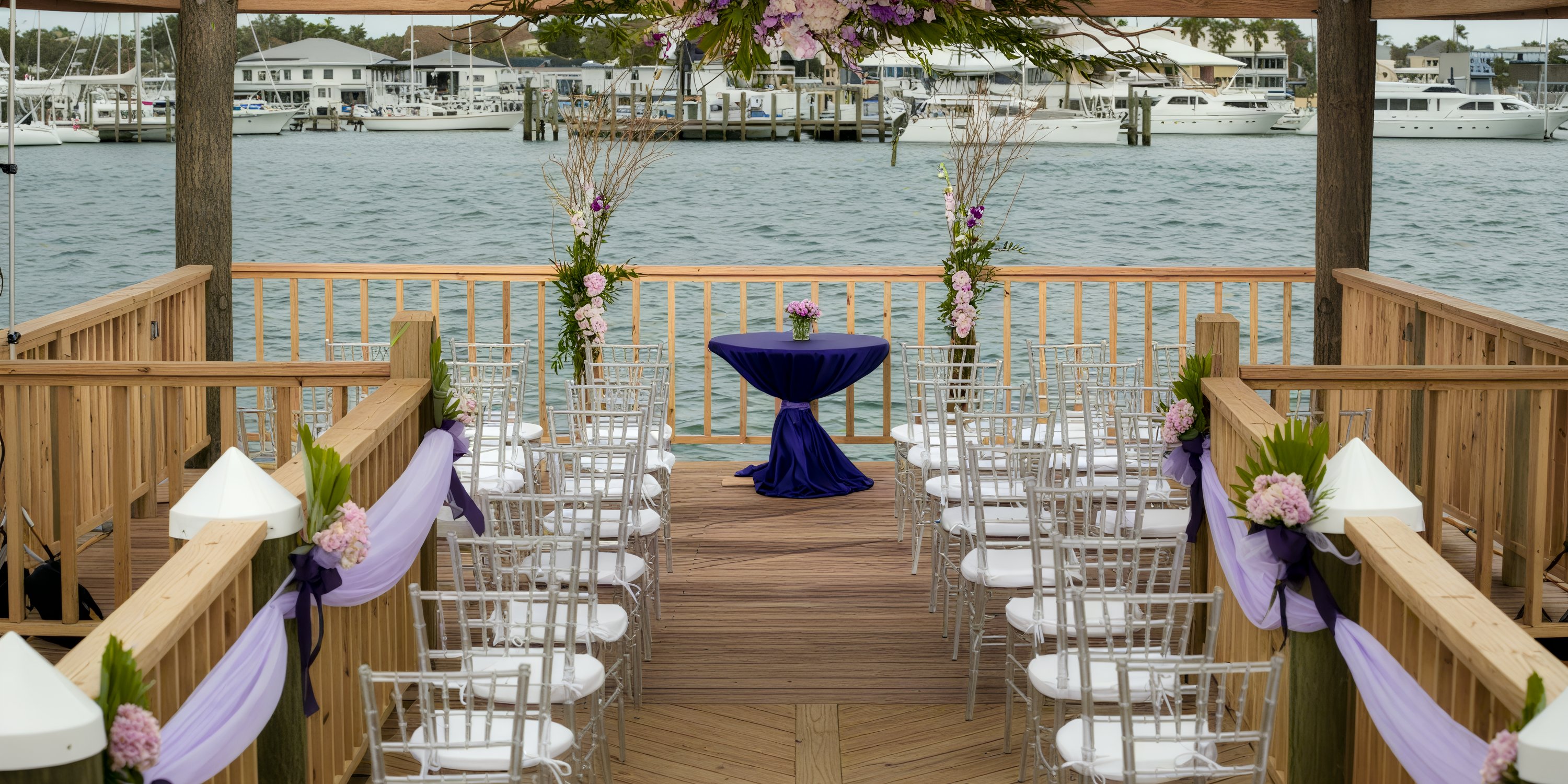 Destination wedding setup at Warwick Paradise Island Bahamas, featuring purple accents on a wooden dock.