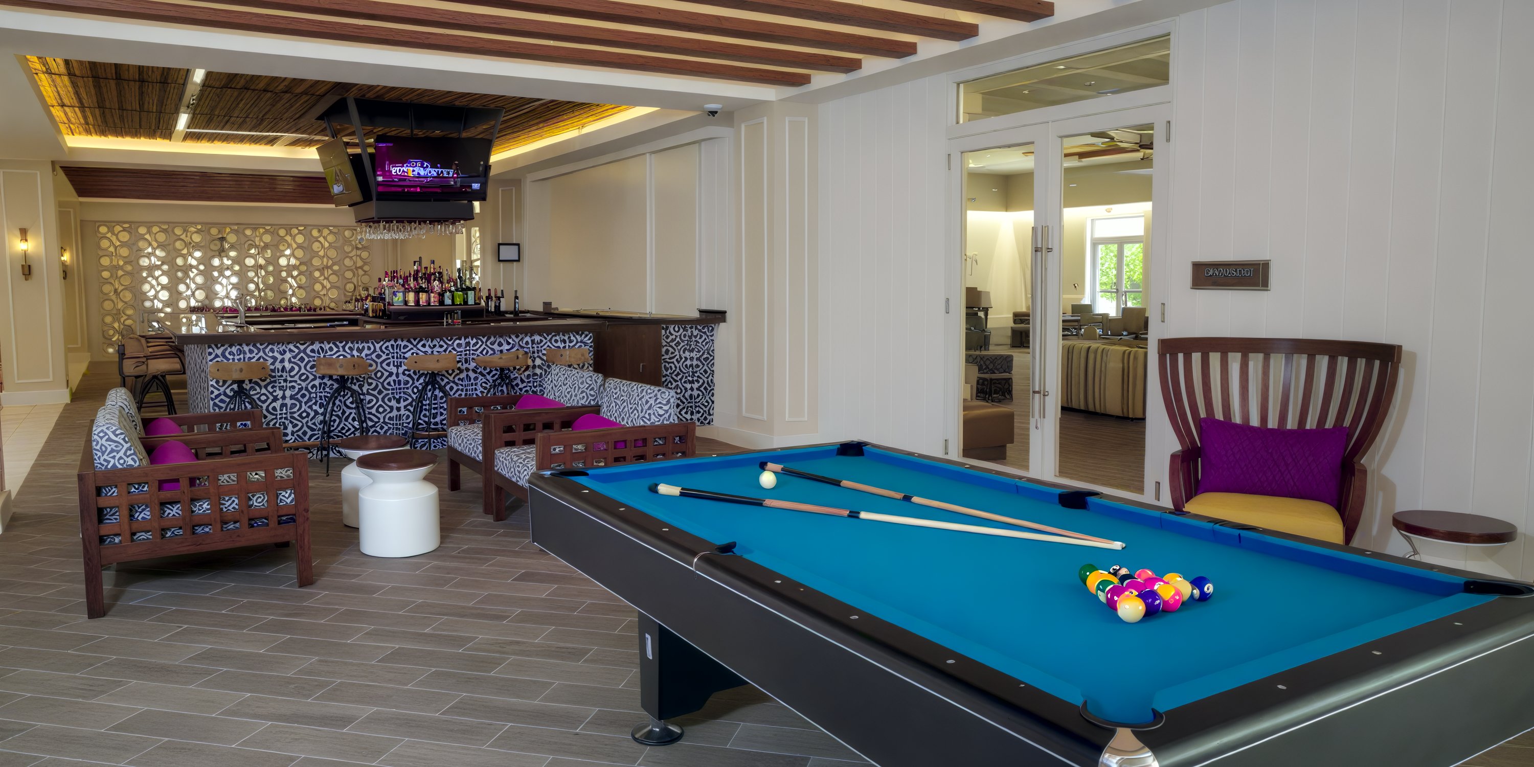 Pool table, bar seating, and TV in Warwick Paradise Island Bahamas lounge—ideal for destination weddings.