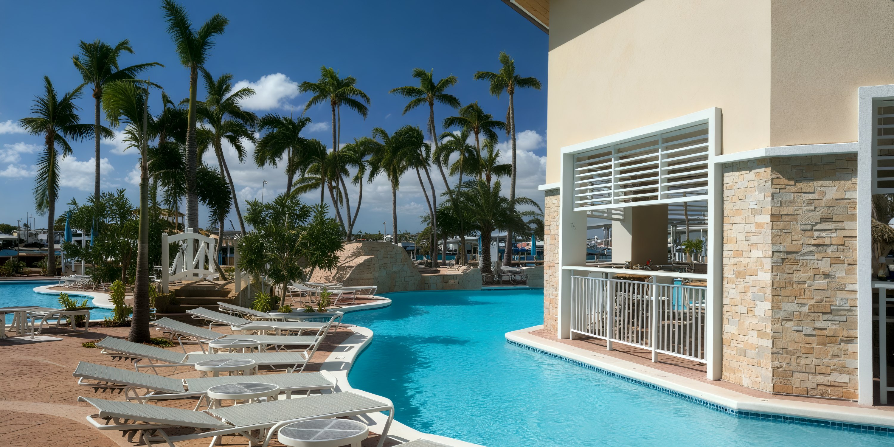 Warwick Paradise Island Bahamas: poolside lounge chairs, palm trees, swim-up bar—perfect for a wedding.