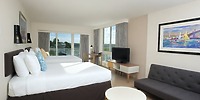 Room at Warwick Paradise Island Bahamas, ideal for a destination wedding: two beds, sofa, TV, desk, view.
