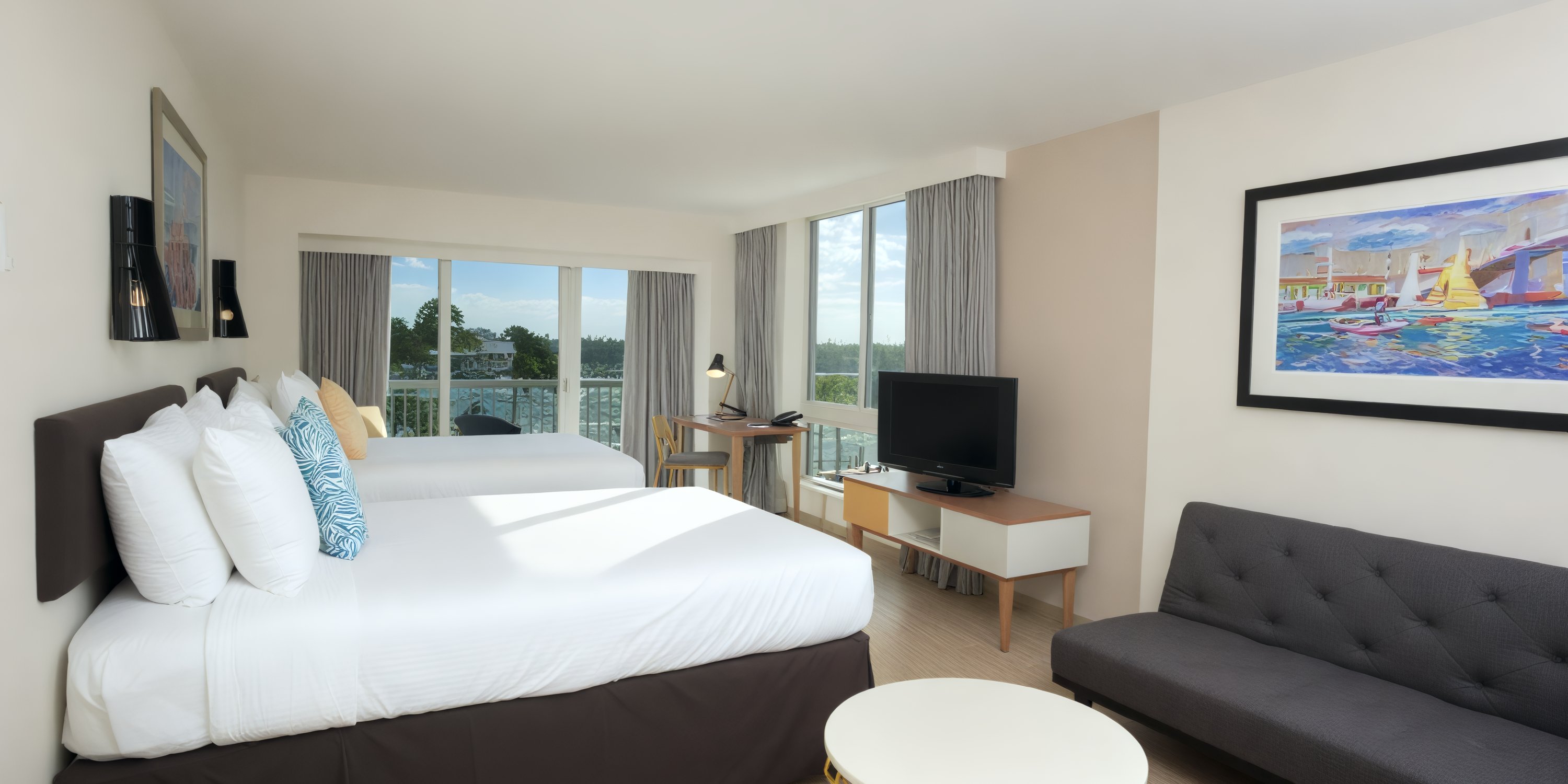 Room at Warwick Paradise Island Bahamas, ideal for a destination wedding: two beds, sofa, TV, desk, view.