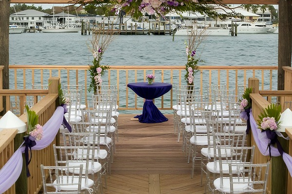 Destination wedding setup outdoors at Warwick Paradise Island Bahamas, featuring white chairs and purple decor.