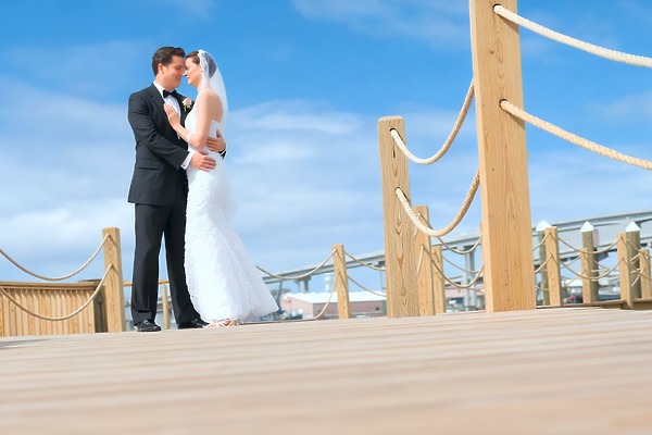 A couple celebrates their destination wedding on a deck at Warwick Paradise Island Bahamas under blue skies.