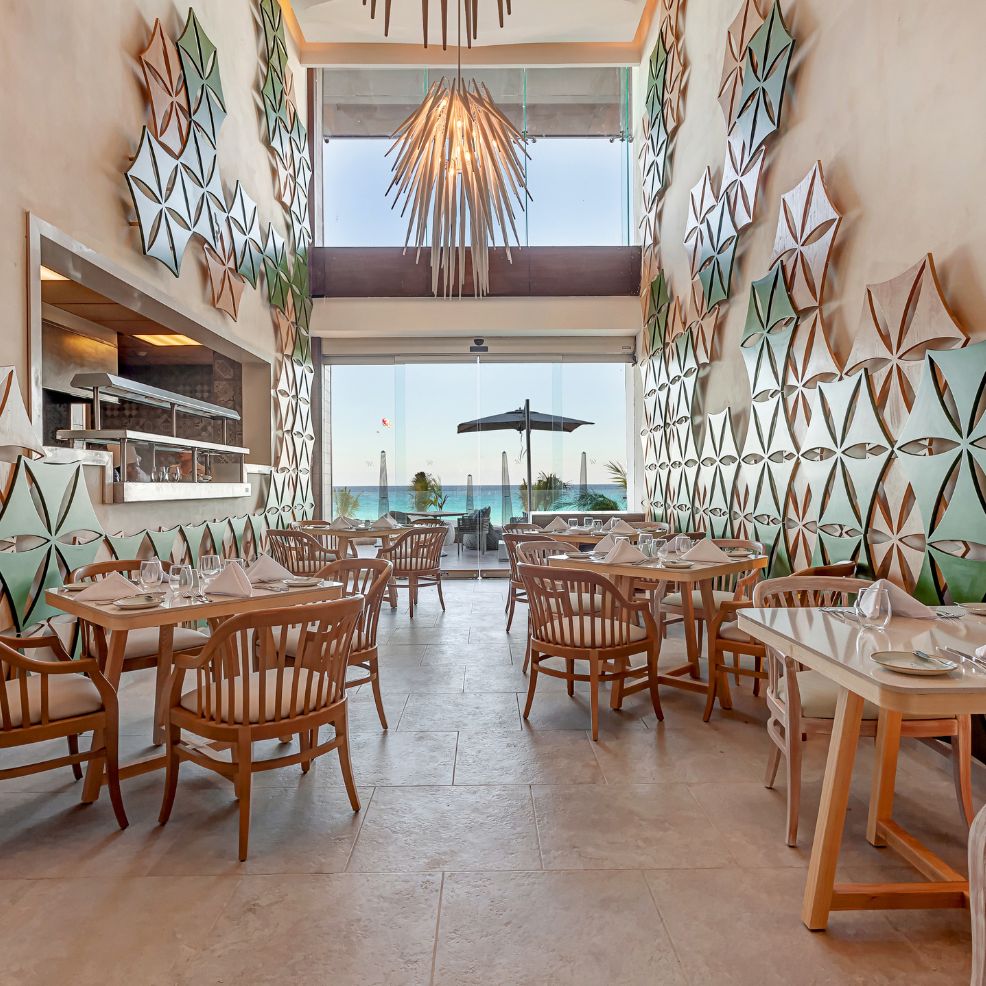 Chic restaurant with wooden tables, geometric art, and big windows—perfect for a destination wedding.