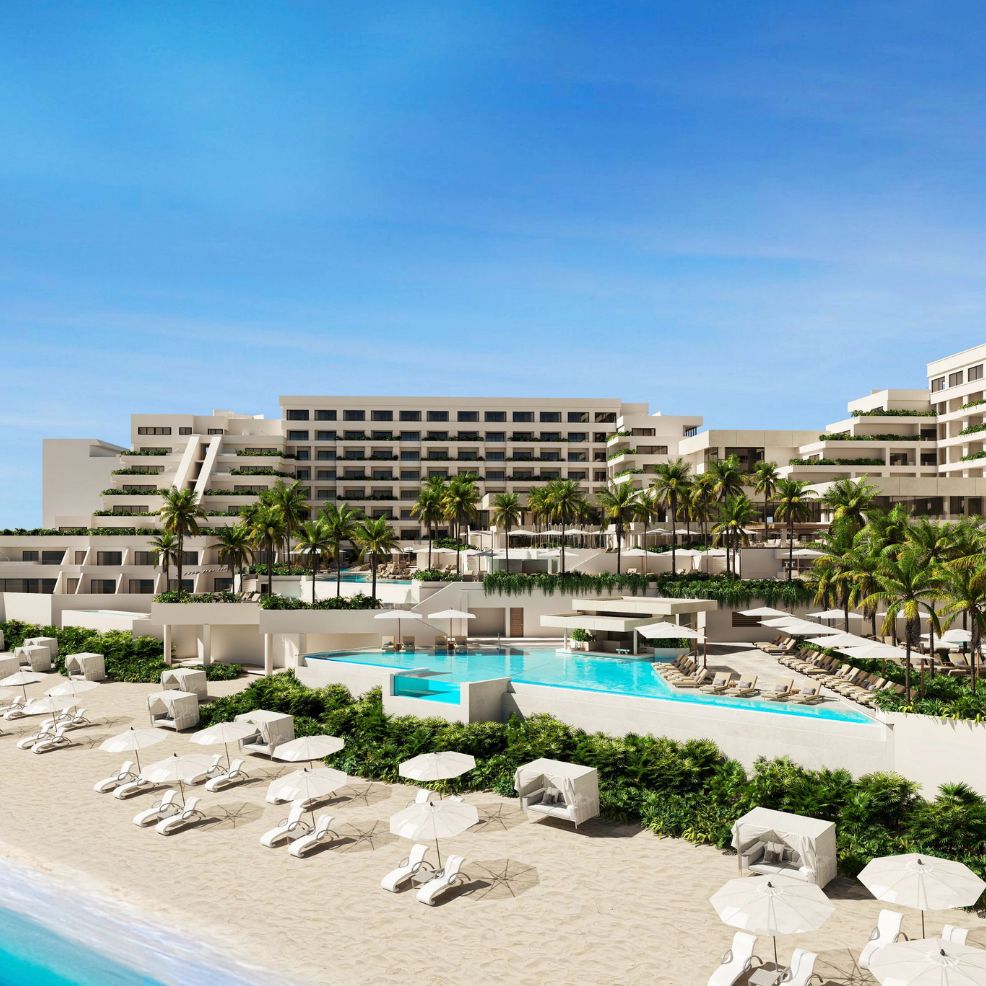 Modern beachfront resort ideal for a destination wedding, with pools, palm trees, and lounge chairs.