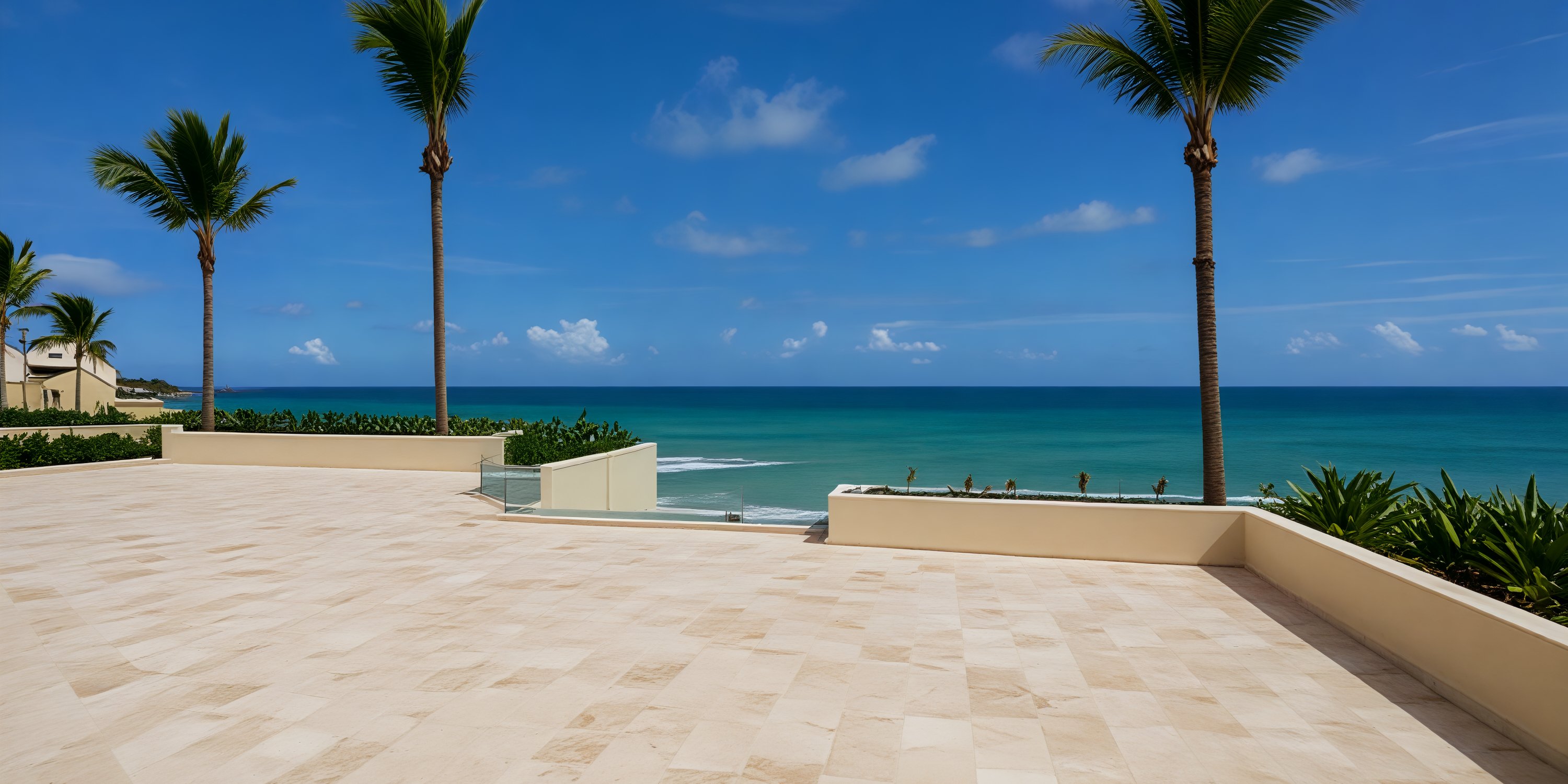 Spacious tiled terrace with palm trees and ocean view, perfect for a destination wedding backdrop.