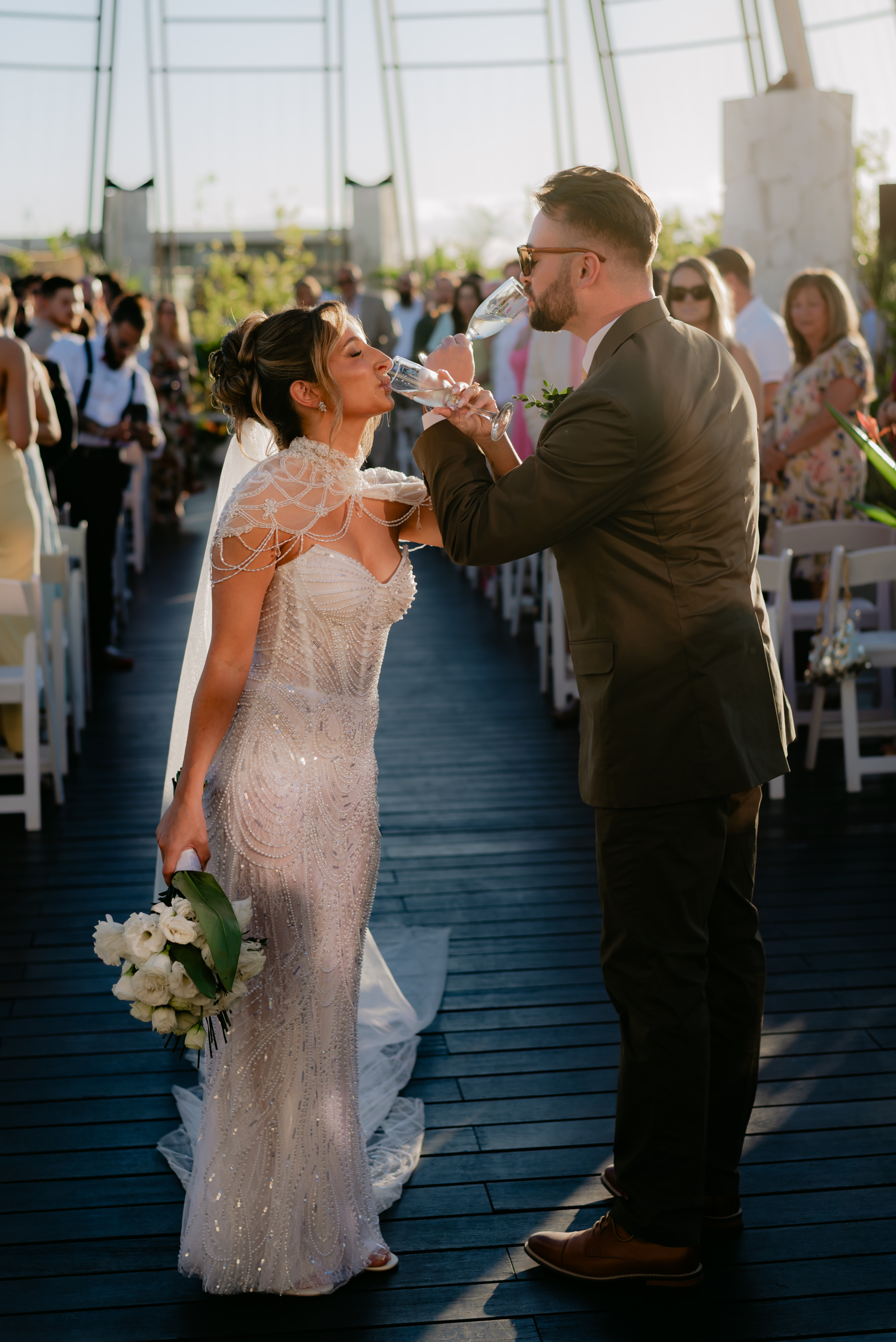 Shirley and William toast with drinks at their beautiful outdoor destination wedding ceremony.