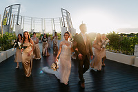 Shirley and William's destination wedding: bride, groom, and bridesmaids in gold at sunset outdoors.