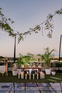 Shirley and William's destination wedding table with plants, candles, and string lights at dusk.