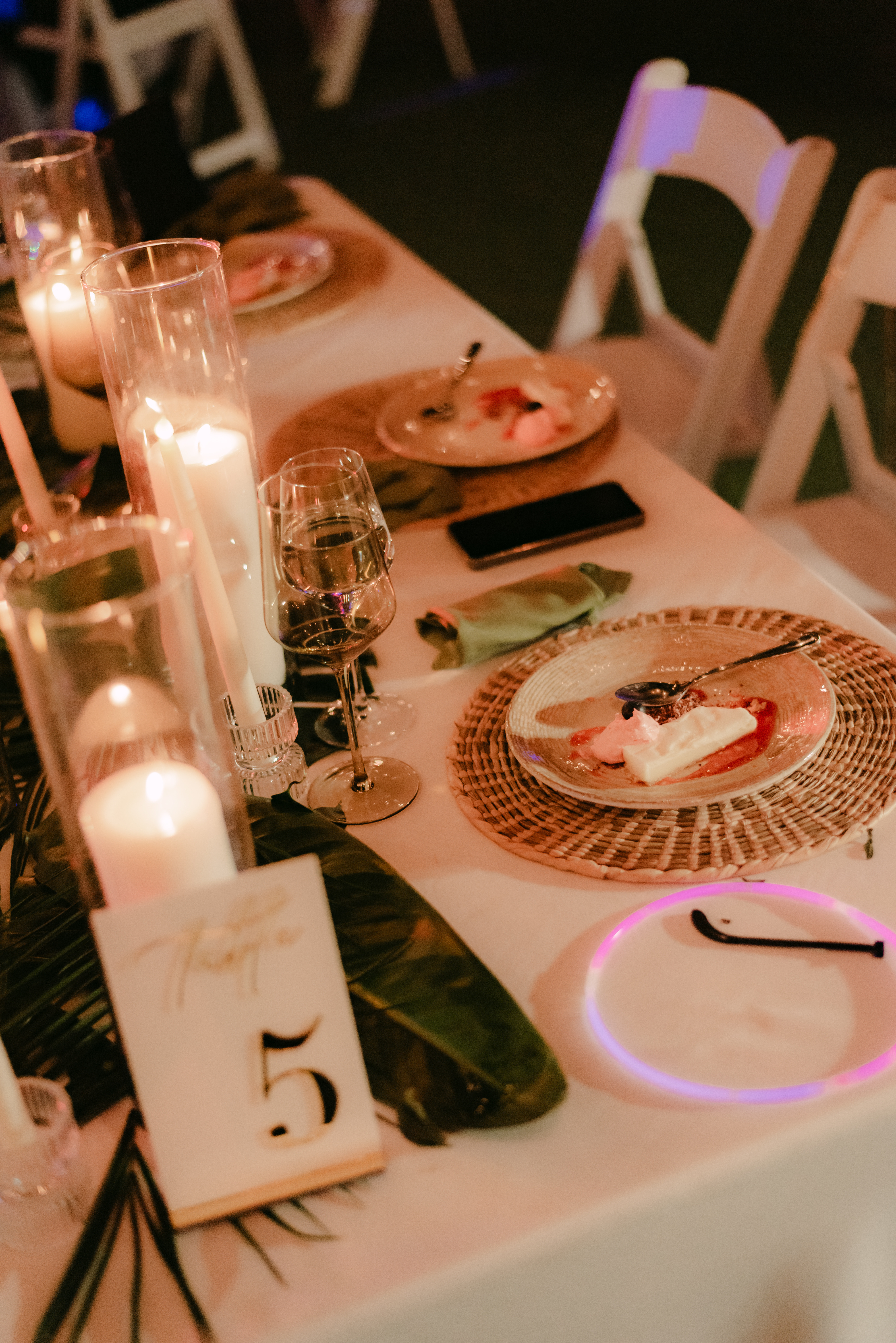 Wedding table set for Shirley and William: candles, dessert plates, wine glasses, table number 5 card.
