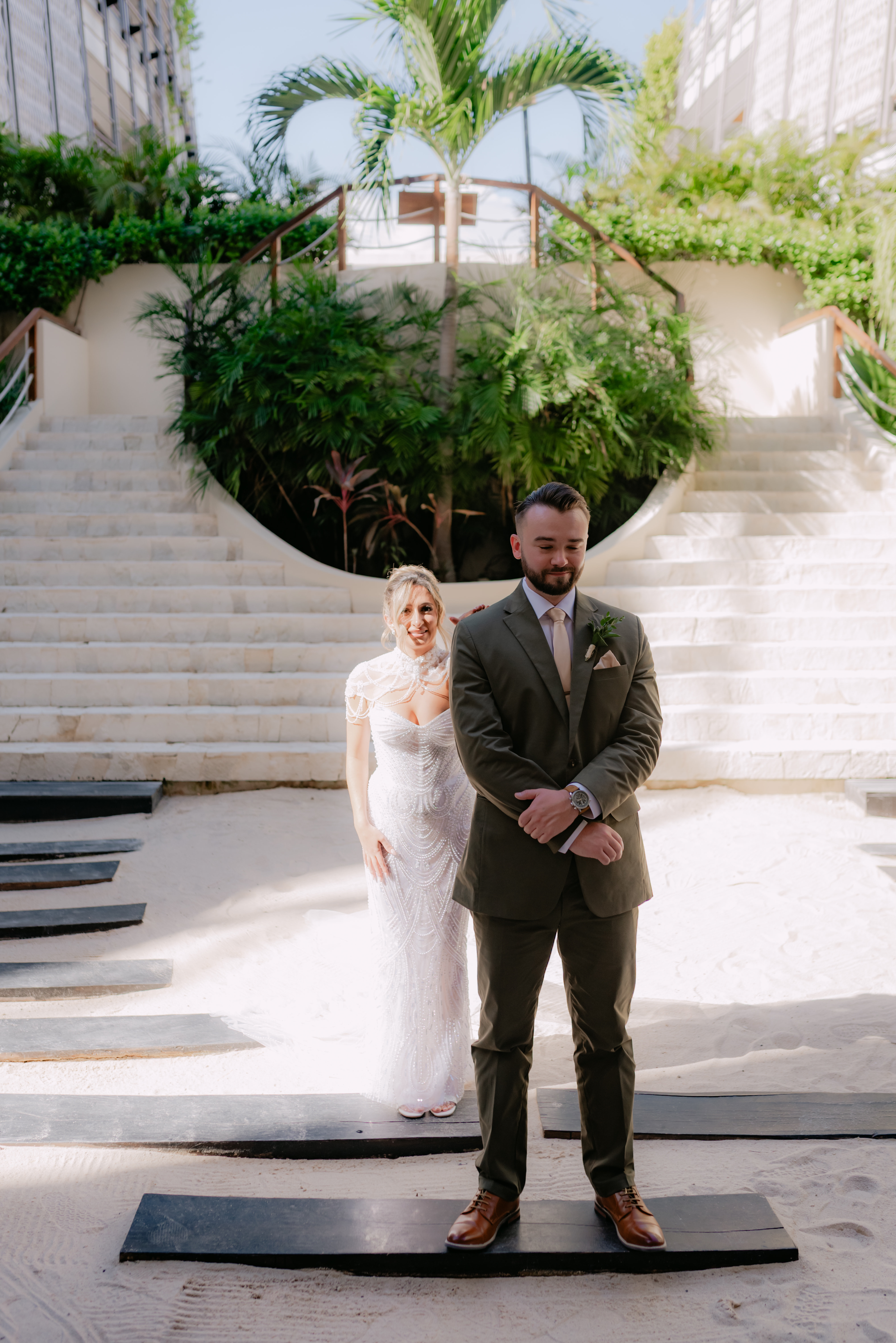 Shirley and William (Copy) pose in wedding attire on a sandy path at their destination wedding.