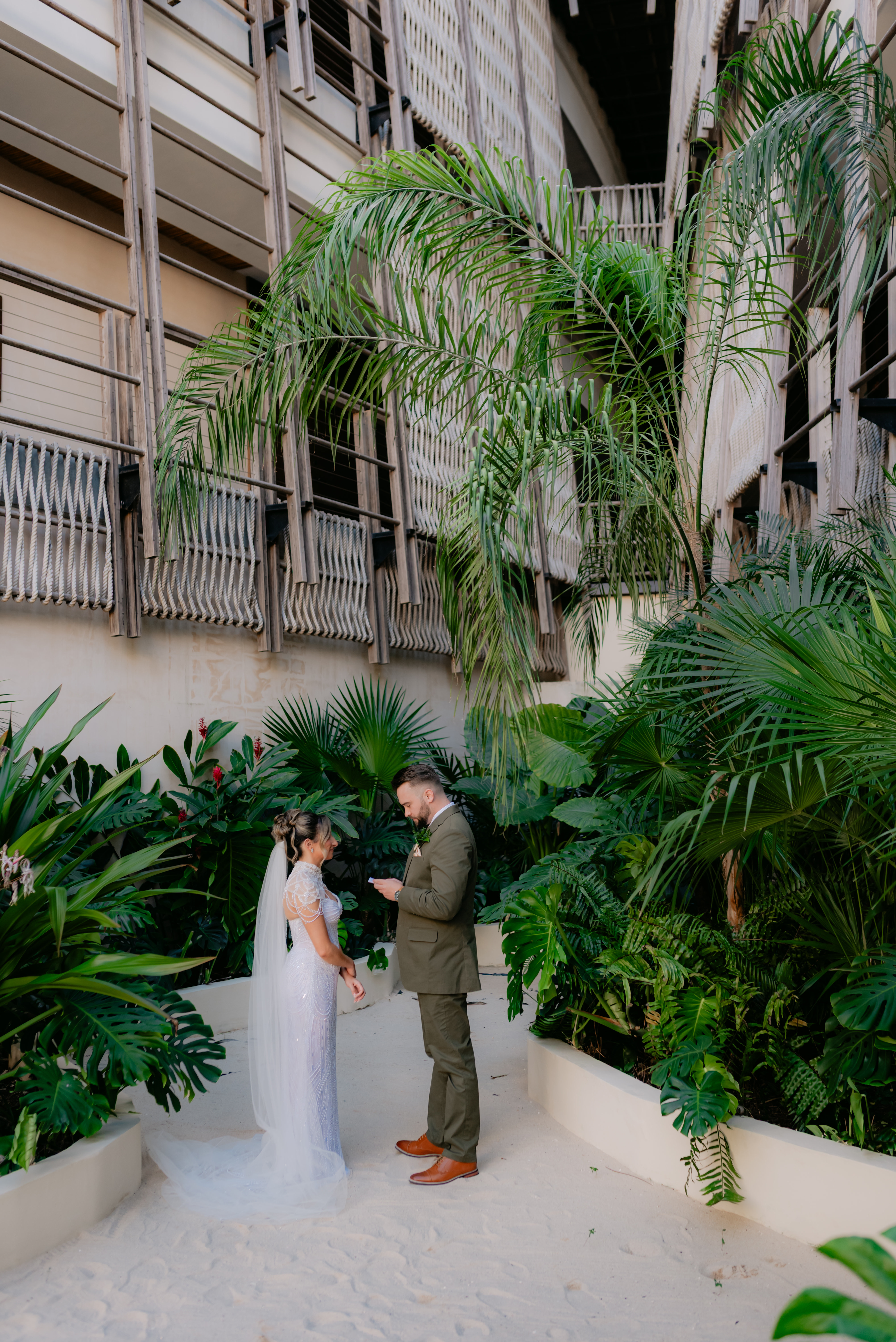 Shirley and William at their destination wedding, standing together in a lush, modern outdoor venue.
